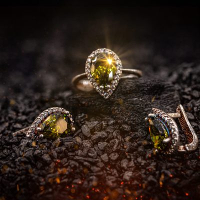 Jewelry ring and earrings witht big yellow gems on black coal background